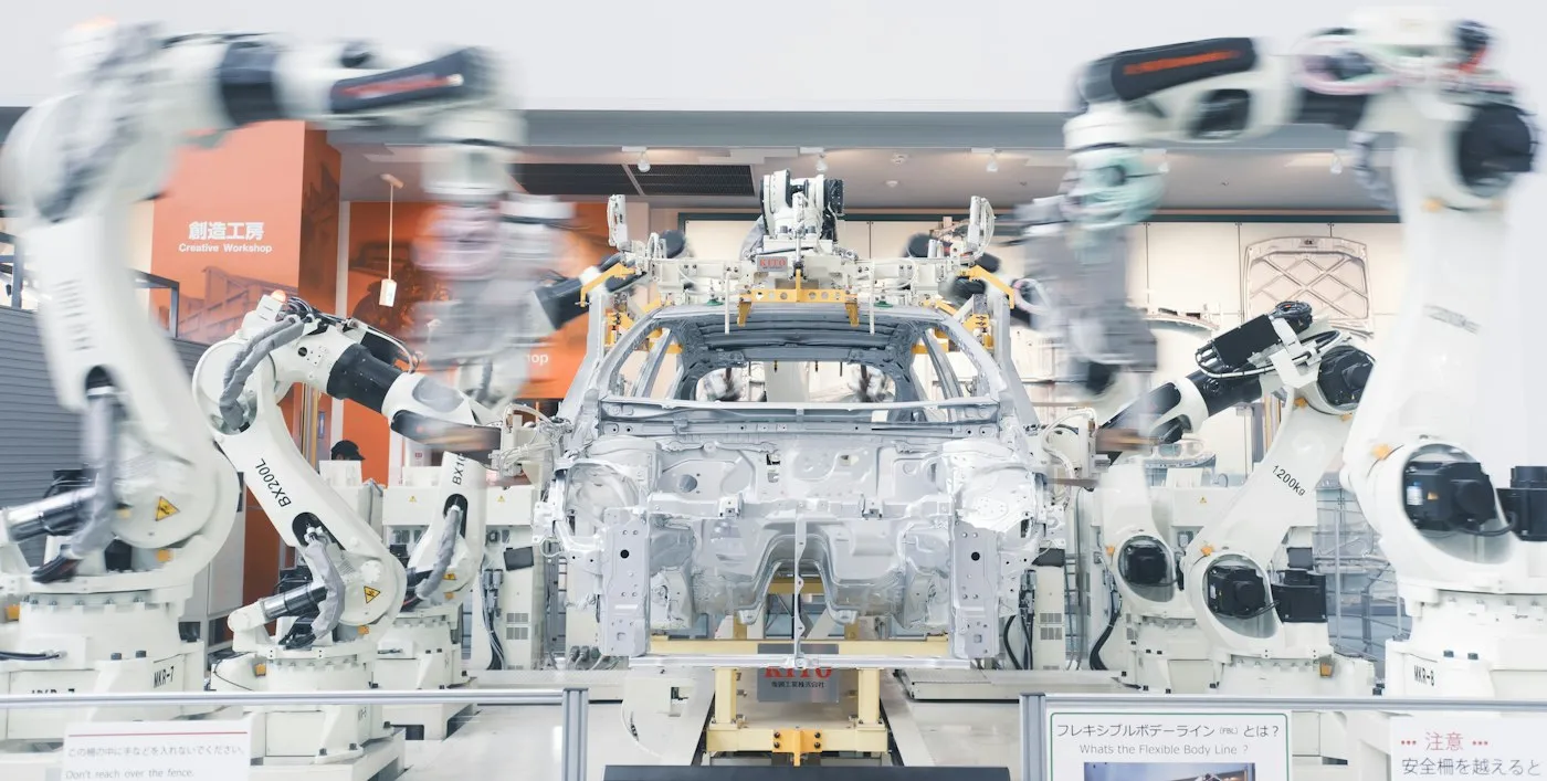 Robotic arms working on a car body in white