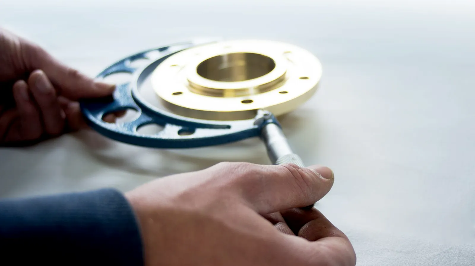 Micrometer measuring a machined brass flange