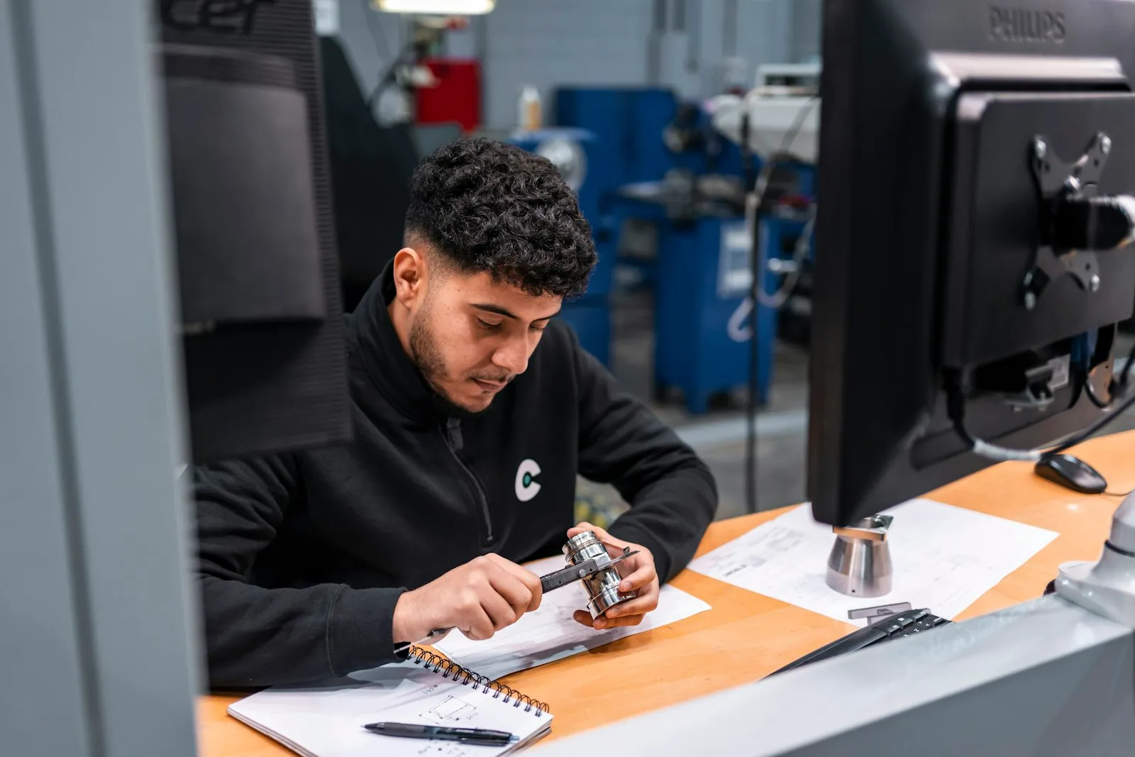 Engineer measuring a machined metal component at an inspection bench