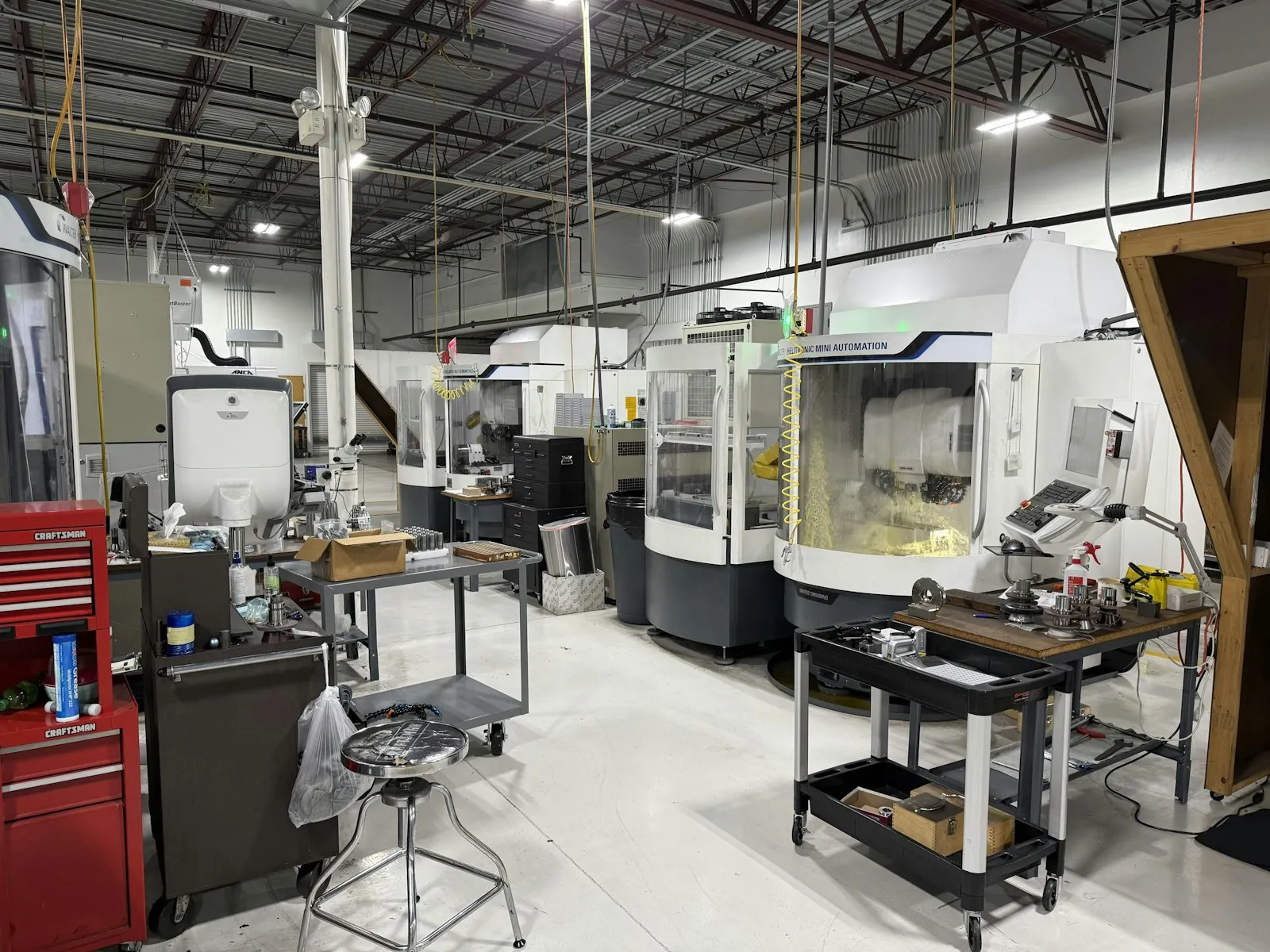 CNC machine shop with machining centers, tool carts and workbenches