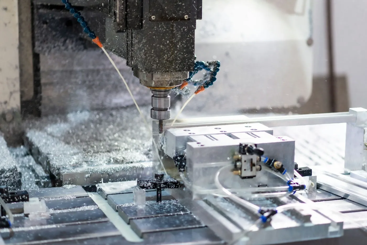 CNC machining center cutting a metal part with coolant